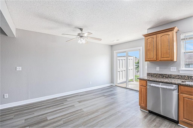 902 SW Peach Tree Ln, Blue Springs, MO 64064 - kitchen featuring stainless steel dishwasher, light wood-type flooring, a ceiling fan, a textured ceiling, and brown cabinets
