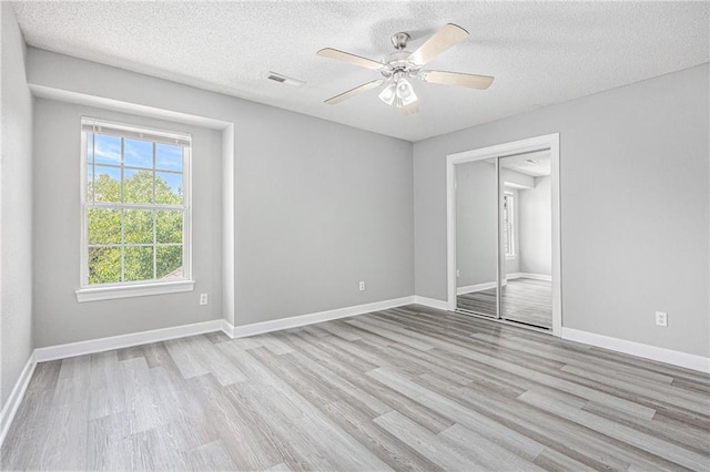 902 SW Peach Tree Ln, Blue Springs, MO 64064 - unfurnished bedroom featuring wood finished floors, a textured ceiling, a closet, and a ceiling fan