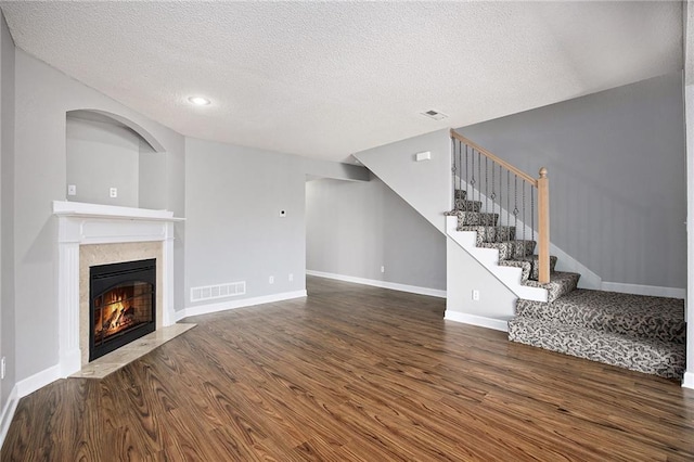 904 SW Peach Tree Ln, Blue Springs, MO 64064 - unfurnished living room featuring wood finished floors, stairs, a textured ceiling, a premium fireplace, and recessed lighting