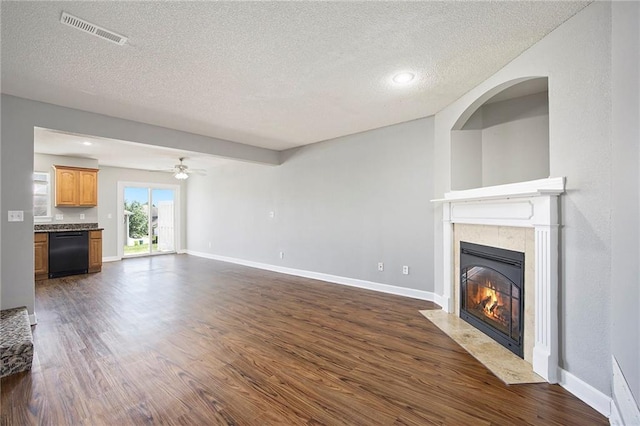 904 SW Peach Tree Ln, Blue Springs, MO 64064 - unfurnished living room with a textured ceiling, a high end fireplace, dark wood-style flooring, and a ceiling fan