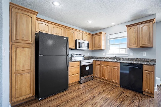 904 SW Peach Tree Ln, Blue Springs, MO 64064 - kitchen featuring black appliances, dark wood finished floors, a textured ceiling, recessed lighting, and dark stone counters