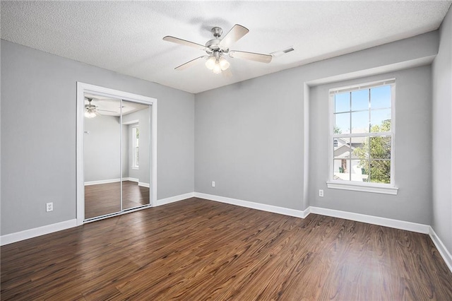 904 SW Peach Tree Ln, Blue Springs, MO 64064 - unfurnished bedroom with dark wood-style flooring, a closet, a textured ceiling, and a ceiling fan