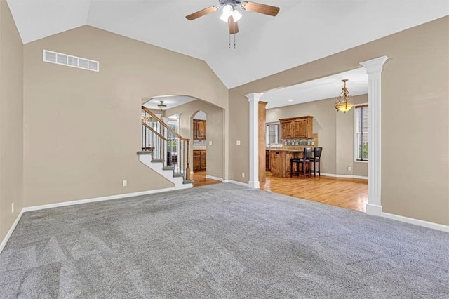895 N Diane Dr, Olathe, KS 66061 - living area featuring light colored carpet, ceiling fan, vaulted ceiling, decorative columns, and stairway