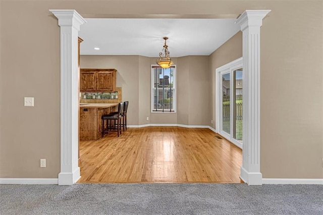 895 N Diane Dr, Olathe, KS 66061 - unfurnished dining area with decorative columns, wood finished floors, and carpet flooring