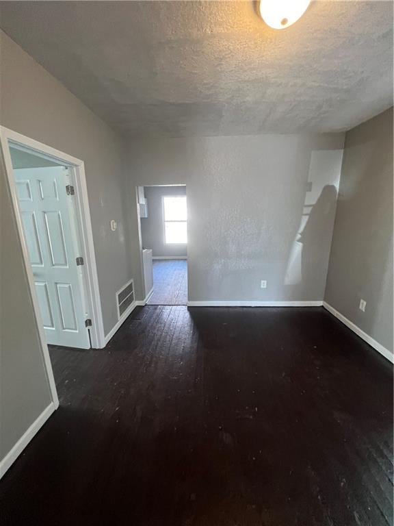4432 E 10th St, Kansas City, MO 64127 - spare room featuring wood finished floors and a textured ceiling