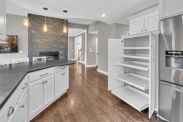 14440 W 187th Ter, Olathe, KS 66062 - kitchen with stainless steel refrigerator with ice dispenser, dark countertops, a fireplace, white cabinetry, and dark wood-type flooring