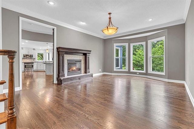 14440 W 187th Ter, Olathe, KS 66062 - unfurnished living room with plenty of natural light, dark wood-style floors, ornamental molding, a glass covered fireplace, and recessed lighting