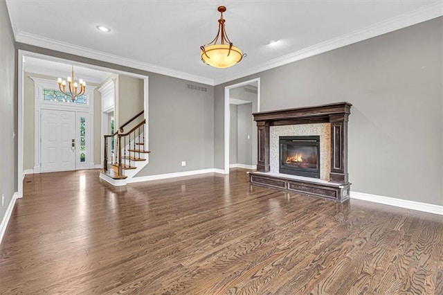 14440 W 187th Ter, Olathe, KS 66062 - unfurnished living room with wood finished floors, a chandelier, ornamental molding, stairway, and a glass covered fireplace