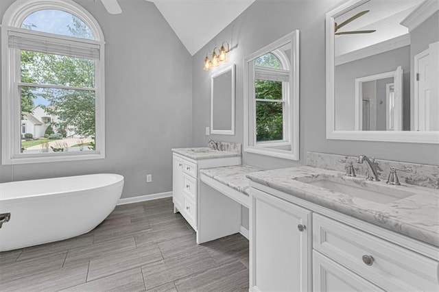 14440 W 187th Ter, Olathe, KS 66062 - full bathroom with two vanities, plenty of natural light, a soaking tub, and lofted ceiling