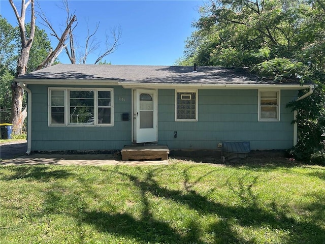 7615 E 48th St, Kansas City, MO 64129 - view of front of home featuring a front yard and roof with shingles