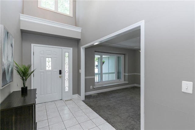 1503 Wrangler Way, Raymore, MO 64083 - foyer entrance featuring light tile patterned floors, light carpet, and a towering ceiling