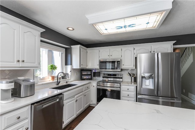 1503 Wrangler Way, Raymore, MO 64083 - kitchen featuring appliances with stainless steel finishes, white cabinetry, tasteful backsplash, light stone counters, and recessed lighting