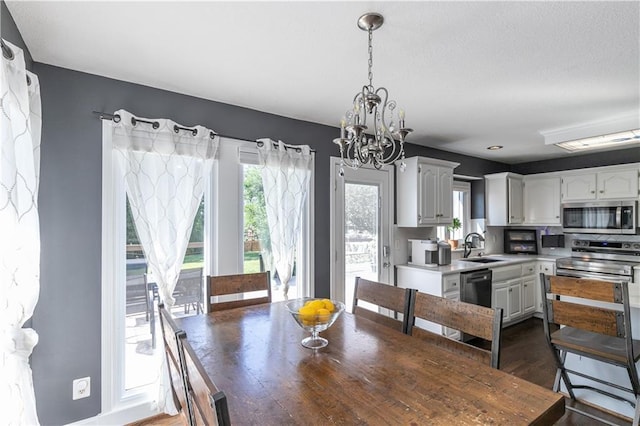 1503 Wrangler Way, Raymore, MO 64083 - dining room with a chandelier, dark wood-type flooring, and a textured ceiling