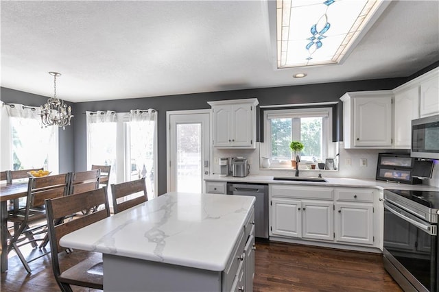 1503 Wrangler Way, Raymore, MO 64083 - kitchen with stainless steel appliances, a chandelier, white cabinetry, a center island, and recessed lighting