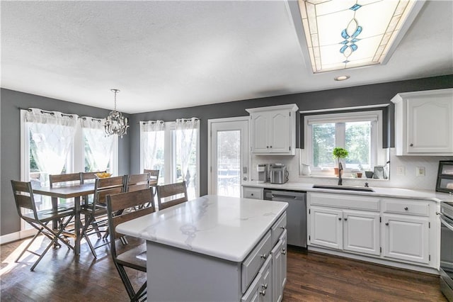 1503 Wrangler Way, Raymore, MO 64083 - kitchen with stainless steel dishwasher, light countertops, a chandelier, dark wood finished floors, and recessed lighting