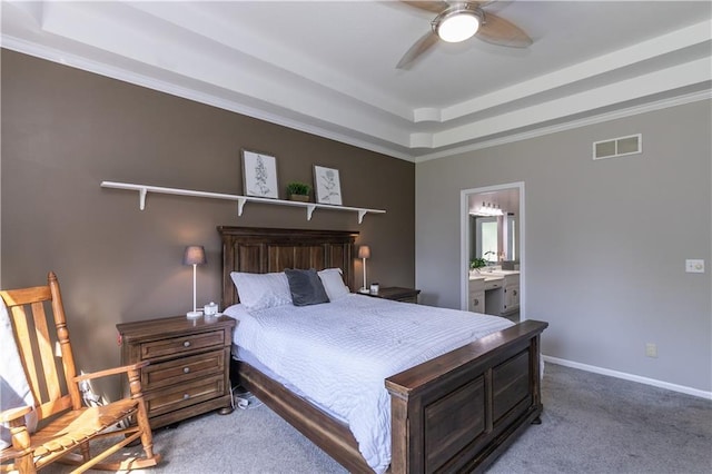 1503 Wrangler Way, Raymore, MO 64083 - carpeted bedroom featuring a tray ceiling, connected bathroom, and ceiling fan