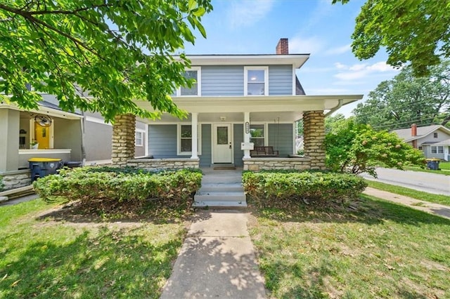 5900 Cherry St, Kansas City, MO 64110 - view of front of home featuring a chimney, stone siding, and covered porch