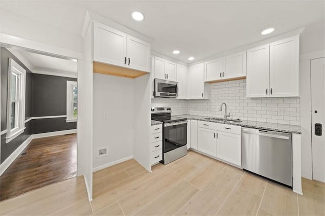 5900 Cherry St, Kansas City, MO 64110 - kitchen featuring stainless steel appliances, light wood-type flooring, light stone counters, white cabinetry, and recessed lighting