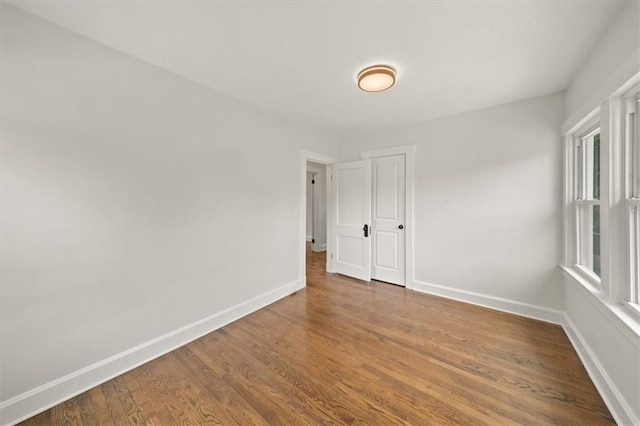 5900 Cherry St, Kansas City, MO 64110 - spare room with wood finished floors and baseboards