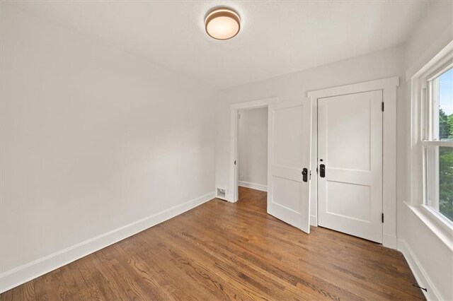 5900 Cherry St, Kansas City, MO 64110 - spare room featuring baseboards and wood finished floors