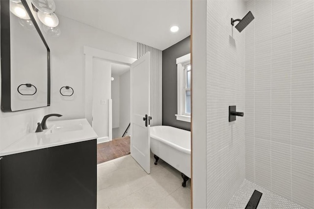 5900 Cherry St, Kansas City, MO 64110 - full bathroom featuring vanity, a freestanding bath, tiled shower, and tile patterned flooring