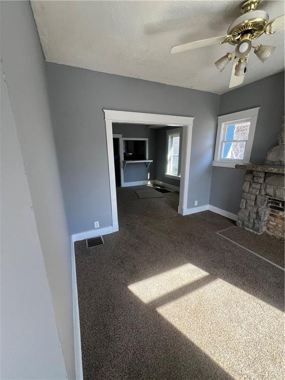 4902 E 17th St, Kansas City, MO 64127 - unfurnished living room with carpet floors, ceiling fan, and a textured ceiling