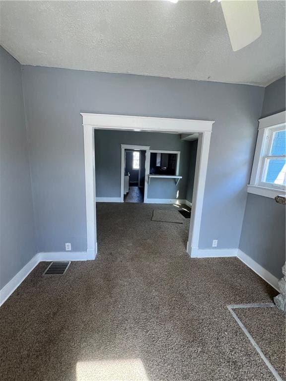 4902 E 17th St, Kansas City, MO 64127 - carpeted empty room featuring baseboards and a textured ceiling