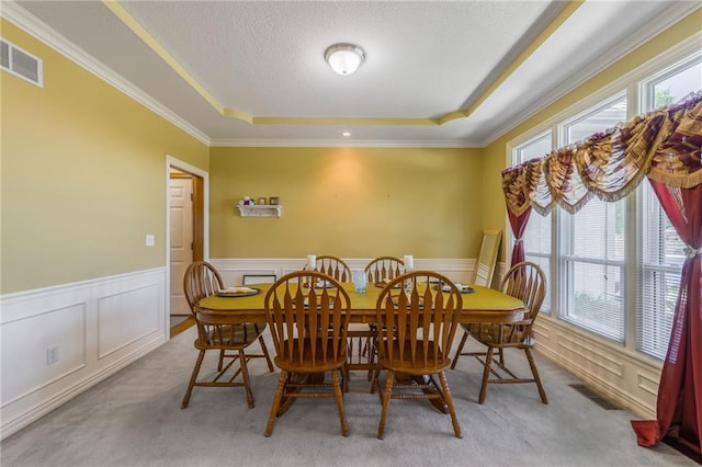 4000 SW Boulder Dr, Lees Summit, MO 64082 - dining space featuring a raised ceiling, plenty of natural light, ornamental molding, carpet floors, and a wainscoted wall