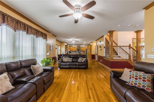 4000 SW Boulder Dr, Lees Summit, MO 64082 - living area featuring ceiling fan, stairs, light wood finished floors, ornamental molding, and ornate columns