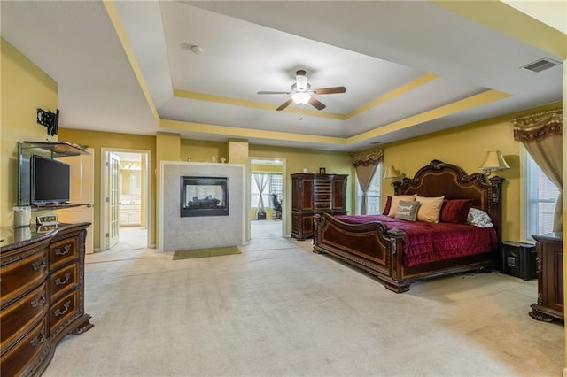 4000 SW Boulder Dr, Lees Summit, MO 64082 - bedroom with a tray ceiling, carpet, a fireplace, and ceiling fan