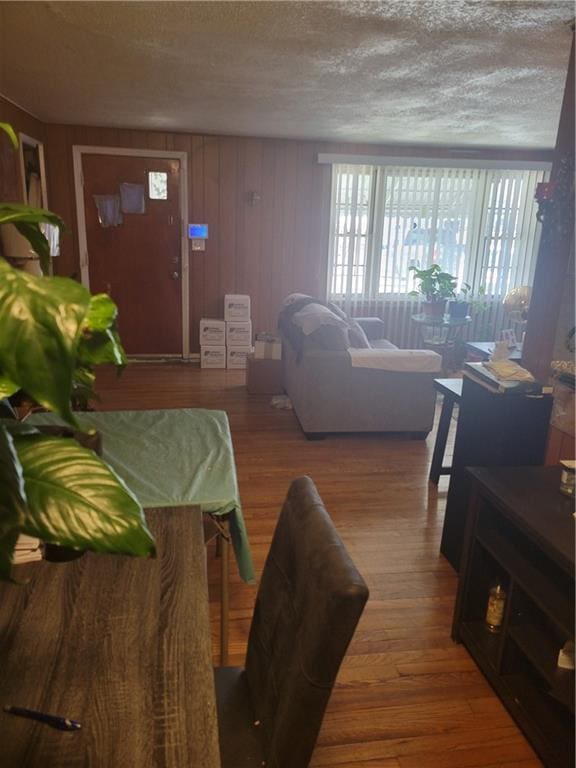 6639 Bales Ave, Kansas City, MO 64132 - living room featuring plenty of natural light, wood finished floors, a textured ceiling, and wood walls