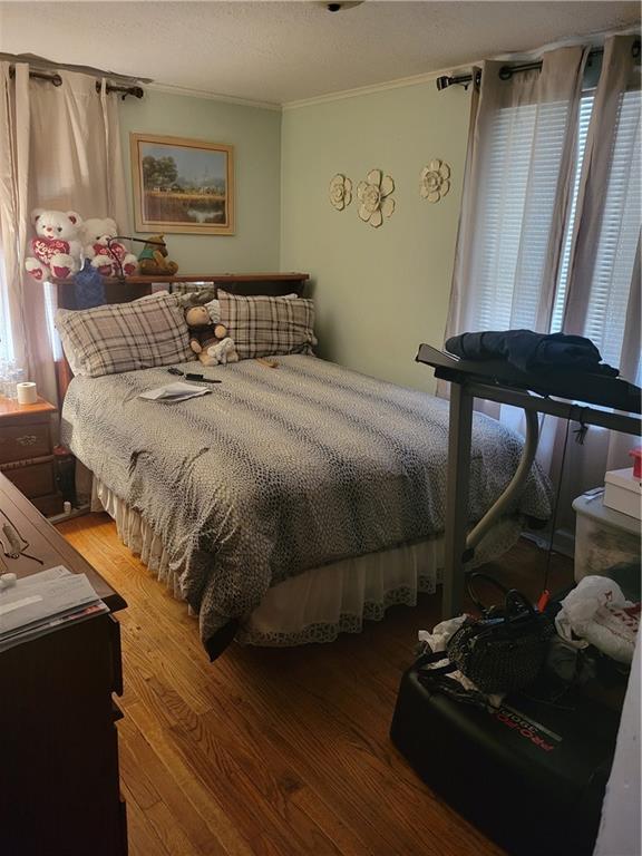 6639 Bales Ave, Kansas City, MO 64132 - bedroom with ornamental molding, light wood-type flooring, and multiple windows