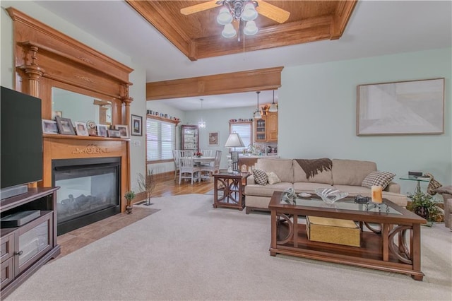 22604 Vincent St, Peculiar, MO 64078 - carpeted living room with a raised ceiling, ceiling fan, a fireplace with flush hearth, and wood ceiling