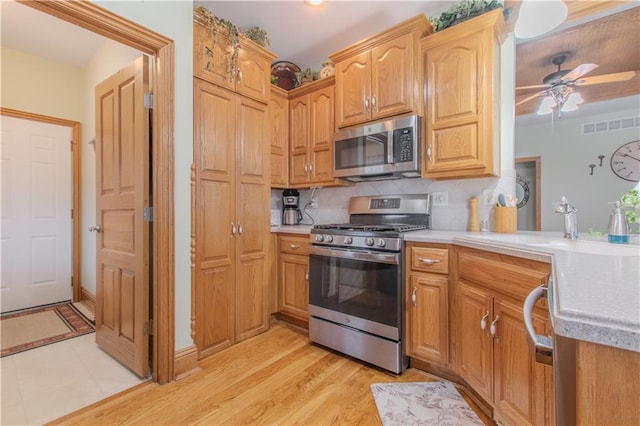 22604 Vincent St, Peculiar, MO 64078 - kitchen featuring stainless steel appliances, light countertops, a ceiling fan, and tasteful backsplash