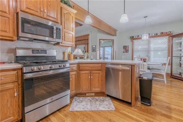 22604 Vincent St, Peculiar, MO 64078 - kitchen with stainless steel appliances, light countertops, light wood-type flooring, and tasteful backsplash