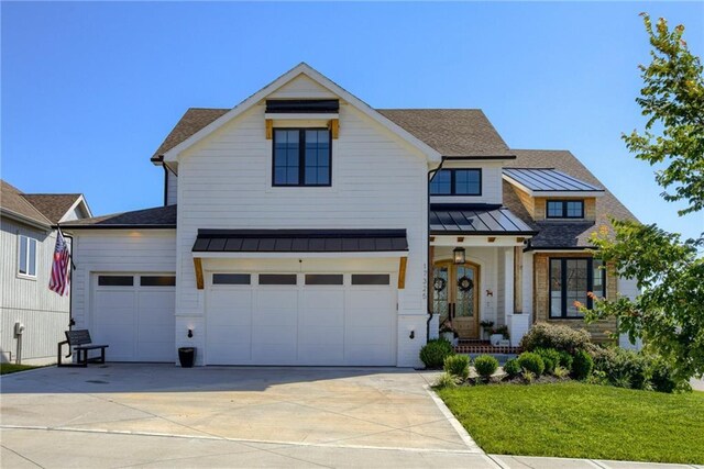 17325 Bradshaw St, Overland Park, KS 66221 - modern farmhouse with a standing seam roof, covered porch, concrete driveway, a front lawn, and a metal roof