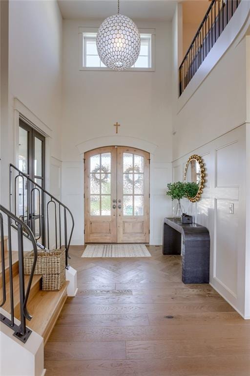 17325 Bradshaw St, Overland Park, KS 66221 - entryway with french doors, wood finished floors, a high ceiling, stairway, and a decorative wall