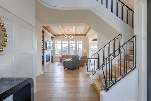17325 Bradshaw St, Overland Park, KS 66221 - entryway featuring a chandelier, stairway, a glass covered fireplace, and wood finished floors