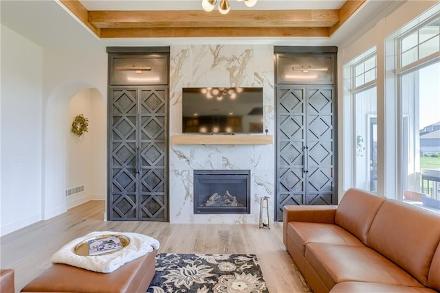17325 Bradshaw St, Overland Park, KS 66221 - living area with wood finished floors, arched walkways, a high end fireplace, and a raised ceiling