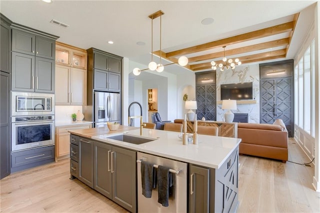 17325 Bradshaw St, Overland Park, KS 66221 - kitchen with stainless steel appliances, a chandelier, light wood-style floors, open floor plan, and beam ceiling