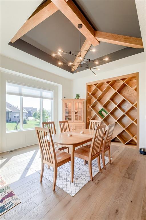 17325 Bradshaw St, Overland Park, KS 66221 - dining space with beam ceiling, a chandelier, and light wood finished floors