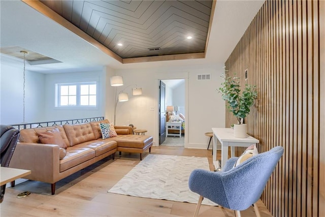17325 Bradshaw St, Overland Park, KS 66221 - living area featuring a tray ceiling, light wood-style floors, wood walls, and recessed lighting