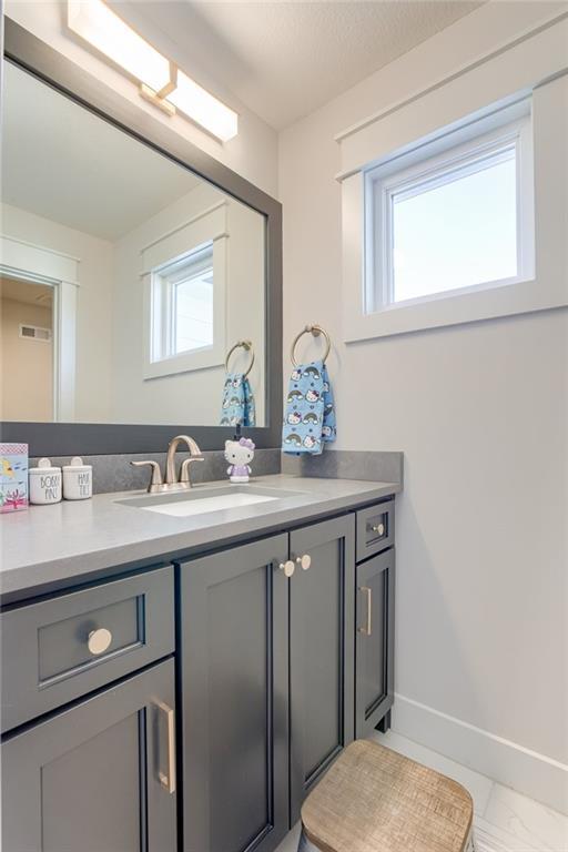 17325 Bradshaw St, Overland Park, KS 66221 - bathroom with vanity and marble look tiles