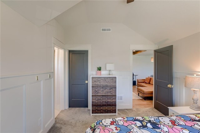 17325 Bradshaw St, Overland Park, KS 66221 - bedroom with a decorative wall, a wainscoted wall, lofted ceiling, and light colored carpet