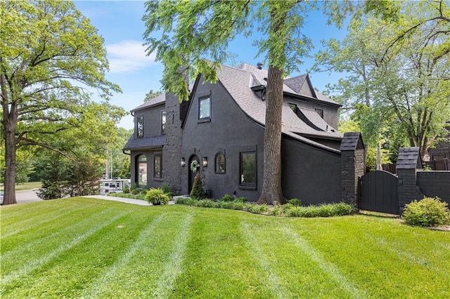 5500 Mission Rd, Fairway, KS 66205 - rear view of property featuring stucco siding, a lawn, a gate, and roof with shingles