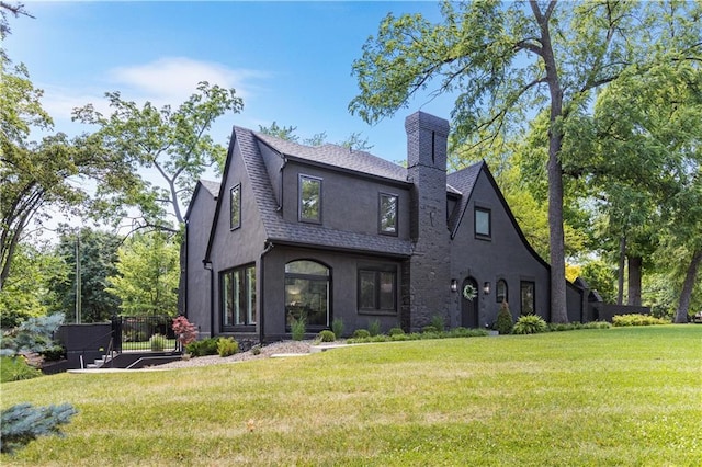5500 Mission Rd, Fairway, KS 66205 - back of house featuring stucco siding, a chimney, a shingled roof, and a lawn