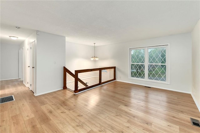 818 N Wigwam Trl, Independence, MO 64056 - empty room with a chandelier and light wood-style flooring