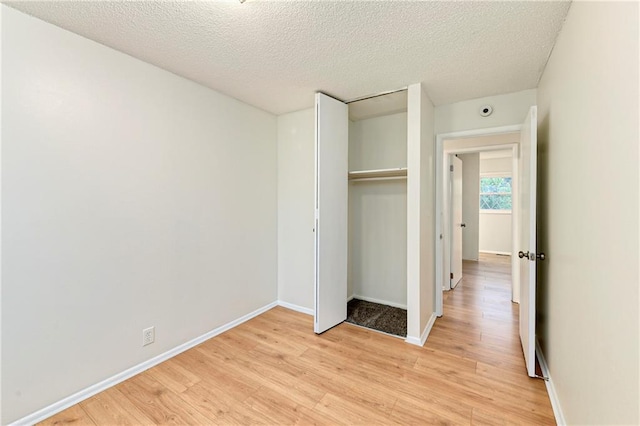 818 N Wigwam Trl, Independence, MO 64056 - unfurnished bedroom featuring light wood finished floors, a closet, and a textured ceiling