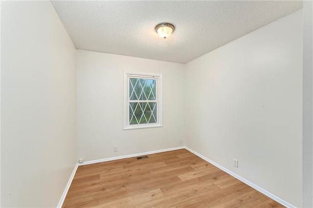 818 N Wigwam Trl, Independence, MO 64056 - unfurnished room with light wood-style floors and a textured ceiling