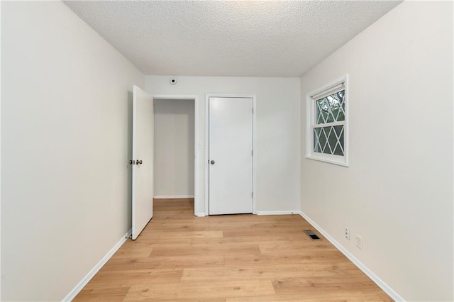 818 N Wigwam Trl, Independence, MO 64056 - unfurnished bedroom with light wood-style flooring and a textured ceiling
